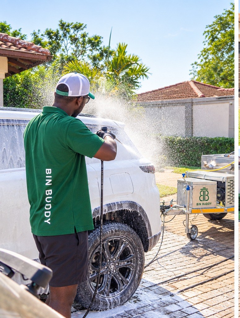 Bin Buddy team member washing a vehicle on a driveway